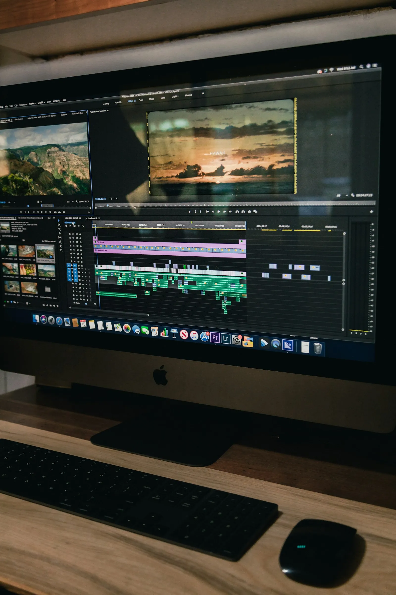 A video-editing timeline open on a desktop screen at a warm wooden desk